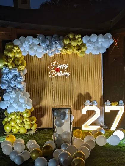 The full garden setup at dusk, with the marquee numbers and neon sign starting to glow.