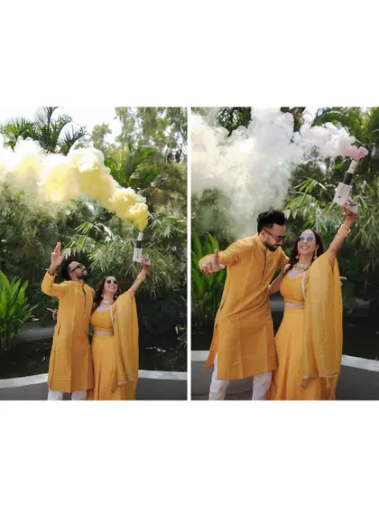 A fun shot of the couple celebrating with color smoke bombs during their Haldi event, adding a modern and festive twist to the traditional ceremony.