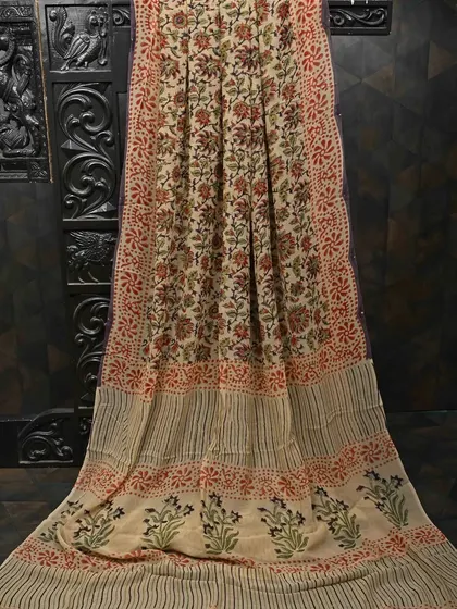 A full view of a block-printed georgette saree in a natural beige color. The intricate floral patterns give it a bohemian-chic vibe, perfect for outdoor events.