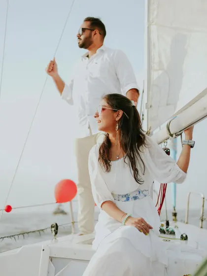A beautiful, breezy shot from a pre-wedding sailboat session, capturing the couple enjoying the moment with the wind in the sails.