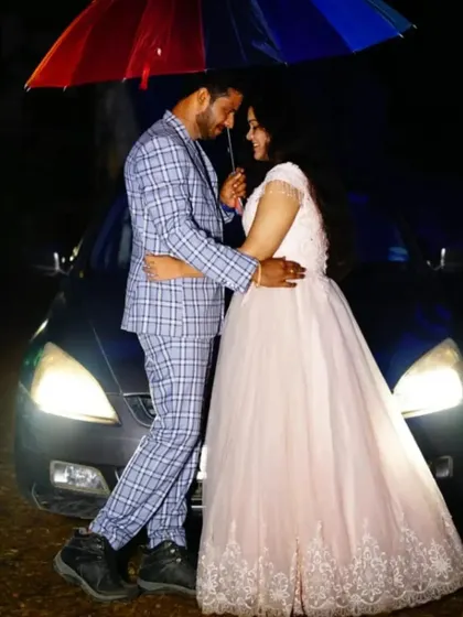 A romantic pre-wedding moment under an umbrella. The client wears our light pink ball gown with delicate embroidery.
