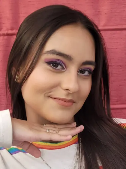 A playful pose showing off the purple semi cut crease makeup. The pop of color on the eyes is fun yet elegant, great for parties or special celebrations.