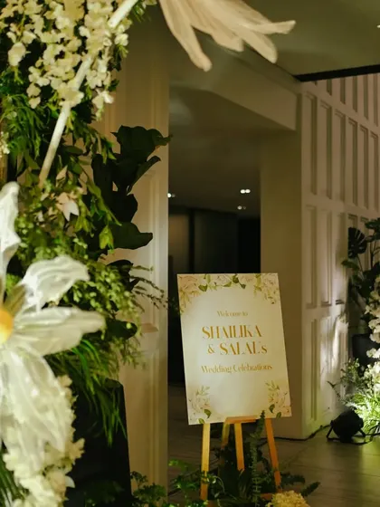 A beautiful welcome setup for guests checking into a destination wedding, featuring an elegant floral arrangement and a custom sign.