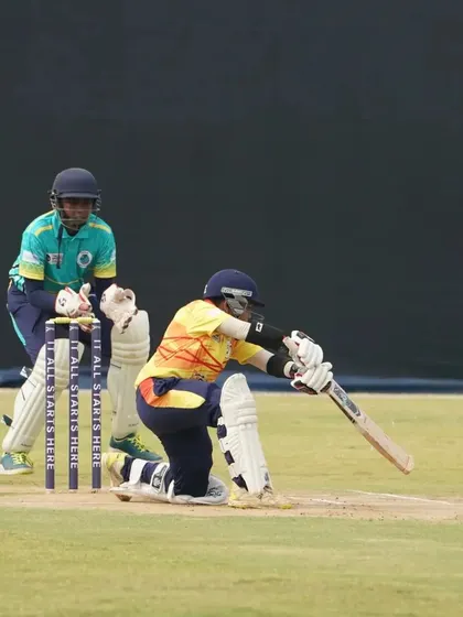 A wicketkeeper and batsman in action during a tense moment in a Debut Cricket League match.