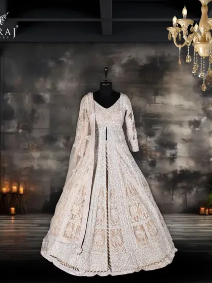 A voluminous peach Indo-Western bridal masterpiece, crafted from delicate net and adorned with intricate aari work and ornamental sequins.