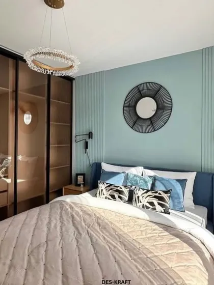 This shot highlights the bedroom's storage solution: a sleek wardrobe with smoked glass doors that add a touch of modern sophistication.