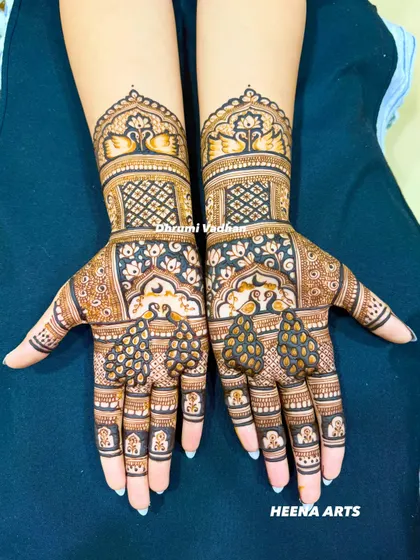 A symmetrical bridal design featuring graceful peacocks on the palms, surrounded by floral patterns. The wristbands showcase elegant swans, adding to the traditional charm.