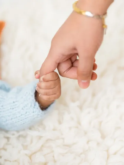 A mother's gentle touch. This photo captures a newborn's hand holding onto mom's pinky finger, a simple and sweet gesture of connection.