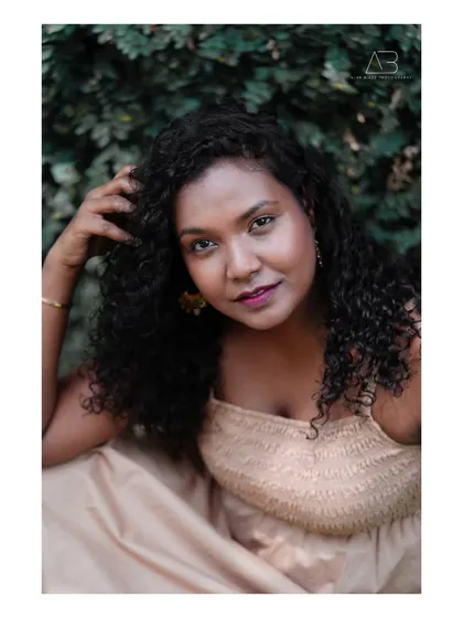 A soft and natural portrait. Her beautiful curly hair and the gentle light create a warm and inviting image, perfect for a personal or professional portfolio.