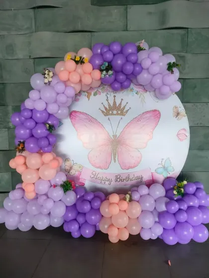 A close-up of the butterfly-themed backdrop with a pretty pastel balloon arch.