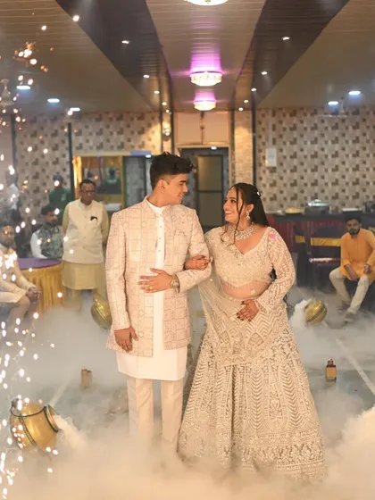A grand entrance for an engagement or reception. The bride's elegant white lehenga is paired with soft, glowing makeup for a modern and ethereal look.