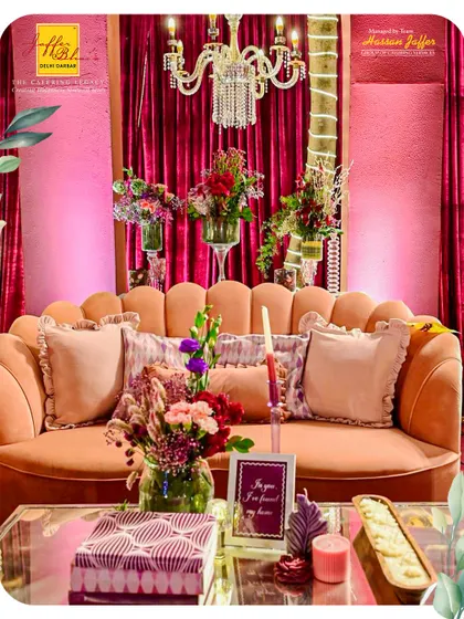 A close-up of a cozy and elegant seating arrangement. The scalloped velvet sofa, adorned with plush cushions and surrounded by fresh flowers, provides a perfect photo opportunity and a comfortable spot for guests.