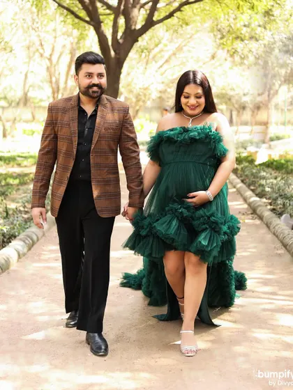 Walking hand in hand towards their next great adventure. This outdoor maternity photo captures the couple in motion, dressed elegantly against a natural backdrop.