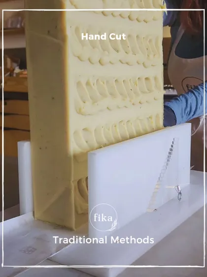 I use traditional methods to create my products. This large, textured soap loaf is being positioned in a single-wire cutter, a simple tool that allows for a clean, precise slice every time.