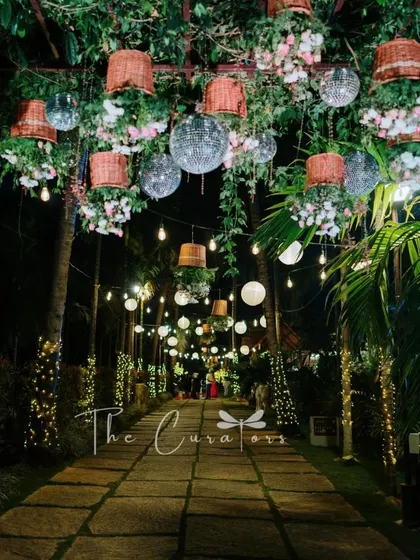 A closer look at the reception pathway at night, where the combination of rustic elements and shimmering lights creates a unique, glamorous feel.