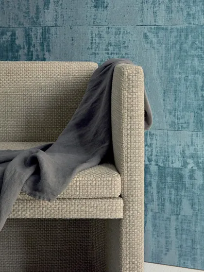 The 'Brumes Existentielles' wallpaper from Élitis captures the essence of artisanal craftsmanship. The textured design, which mimics coated raffia, is brought to life in a refreshing blue hue, adding a modern and artistic touch to the space.