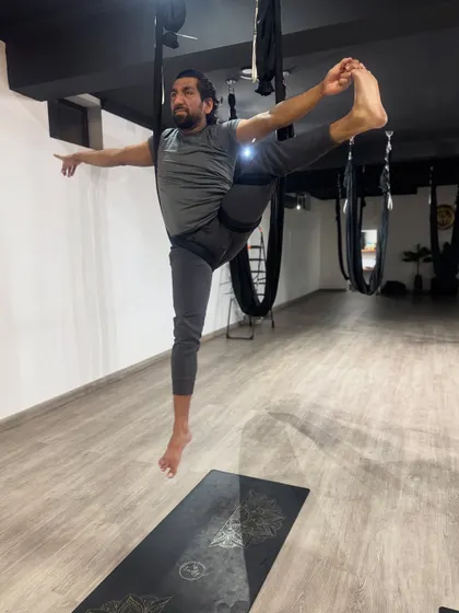 Floating in a supported hand-to-big-toe pose, this image showcases the balance, flexibility, and strength that our practice develops.
