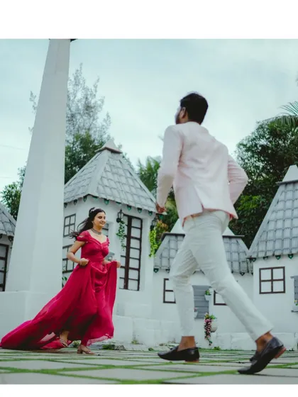 A playful chase in a fairytale setting. The bride's flowing pink gown adds a touch of whimsy and romance to this fun and candid pre-wedding moment.