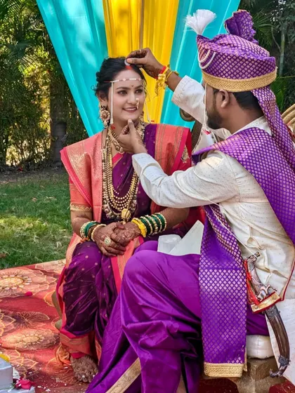 A sacred moment during the wedding rituals. The bride's traditional makeup, complete with a bindi and mundavalya, is perfectly suited for the cultural ceremony.