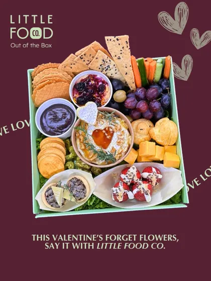 My Valentine's Day special grazing box, designed for a romantic evening. It features heart shaped details and a mix of indulgent treats like baked brie, truffle profiteroles, and chocolate covered strawberries.