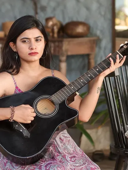 A collection of relaxed, bohemian-style portraits taken at a rustic cafe. The model is featured in a flowing paisley dress, interacting with props like a guitar, creating a natural and artistic vibe.