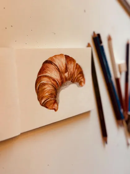 A different angle of the color pencil croissant drawing.