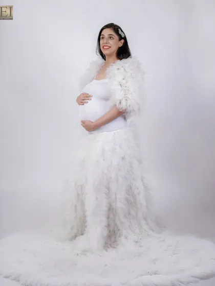 Another pose in the beautiful white feathered gown, showcasing its texture and long train.