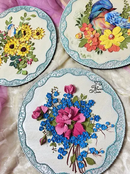 A closer look at two of the three plates from the set, highlighting the bird and bouquet designs.