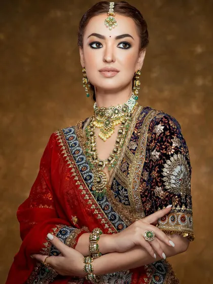 A close-up focusing on the rich textures of the velvet blouse and the antique finish of the traditional bridal jewelry.
