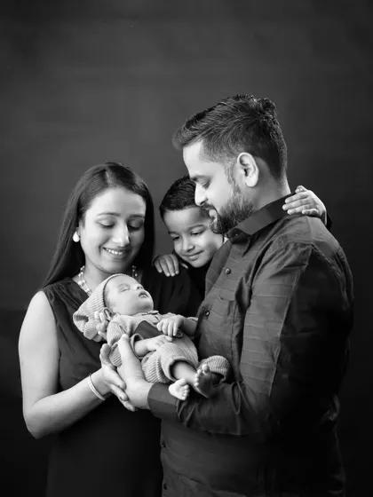 A candid moment of adoration. The family gazes lovingly at their newest member, a perfect capture of their new family dynamic.