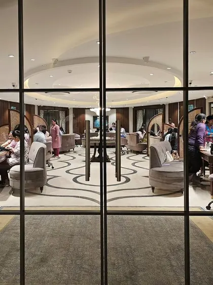 A view through the glass doors at KR Sons reveals the store's unique layout. The curved seating and patterned floor guide the eye, while the arrangement of private consultation areas is visible, showcasing a design that balances openness and intimacy.