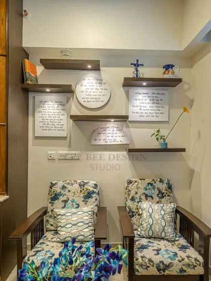 A close-up of the reading nook from image 3, showing the floral chairs and framed manuscripts.