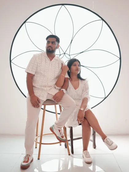 A stylish, high-fashion pose against a minimalist white backdrop with an artistic floral motif. This shot is perfect for couples who want a modern and artistic feel for their pre-wedding photos.