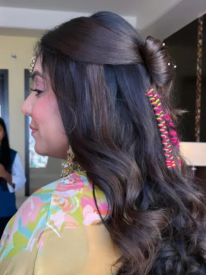 A half-up style with a twist and colorful thread-wrapped accent braids. This is a creative and playful look, perfect for a fun-loving bride's Mehendi ceremony.
