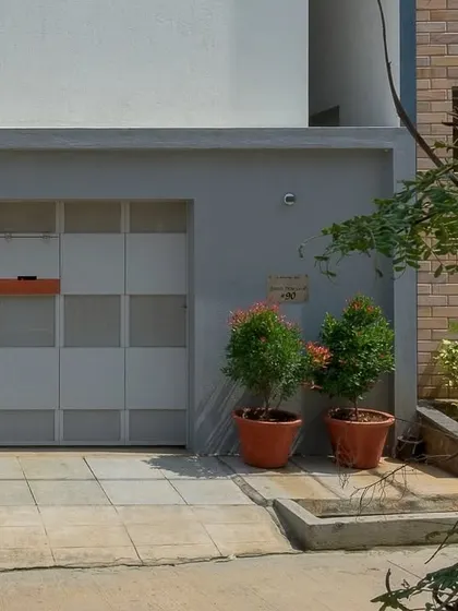 The simple, panelled gate and grey compound wall were intentionally designed to draw the eye upward towards the intricate brickwork of the main facade.