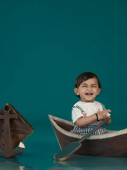A happy little sailor in his boat! Our nautical-themed studio setup is perfect for adventurous little ones.