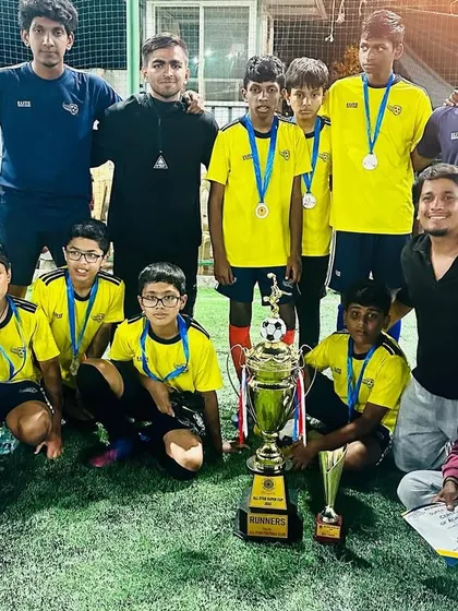 Our Under-15 runners-up team with their coaches. We celebrate every achievement, as both winning and losing are important parts of the learning process.