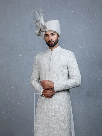 Grace woven in ivory. A sherwani embellished with fine thread embroidery and tiny beads, styled with a pleated stole and a minimal turban with a sarpech, personifying timeless royalty.