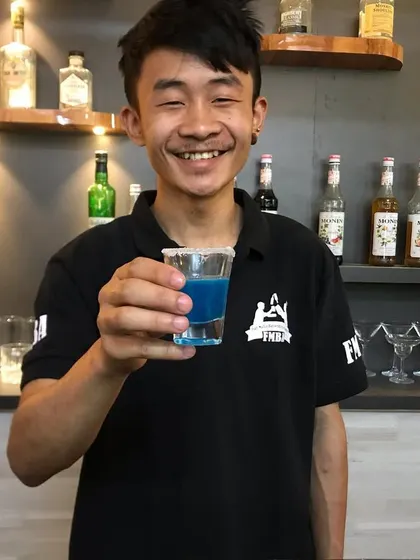 A blue shot, held up by one of our happy bartenders. These are always a hit at parties.