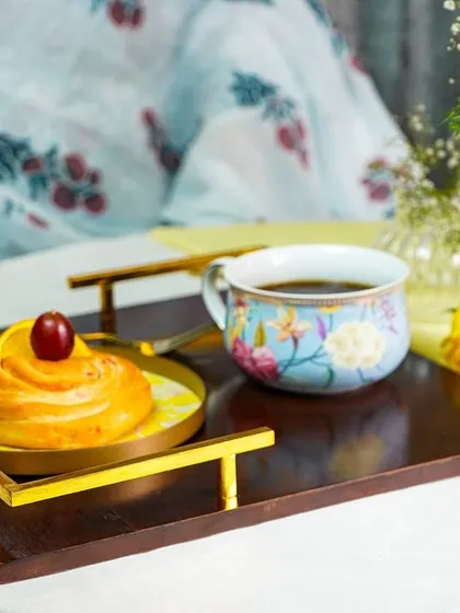 A lifestyle shot of a table setting, with a person in the background. This helps customers visualize how the products would look in their own home.