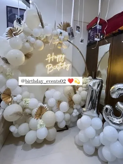 An all-white and gold theme for a 13th birthday, showing how we can adapt our designs for any age. This setup includes hanging polaroid photos for a personal touch.