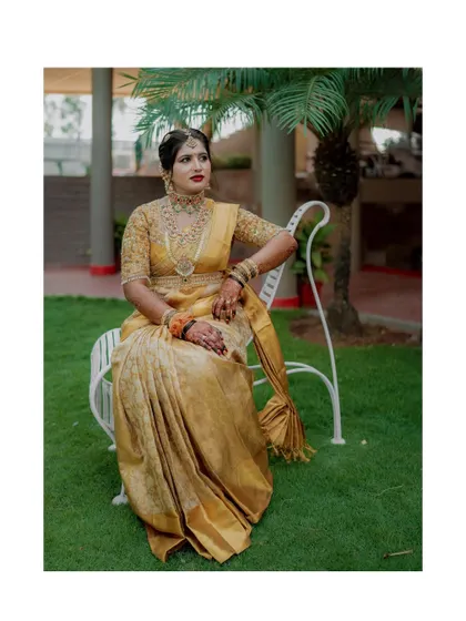 A portrait of the bride in a beautiful golden saree, looking regal and elegant.