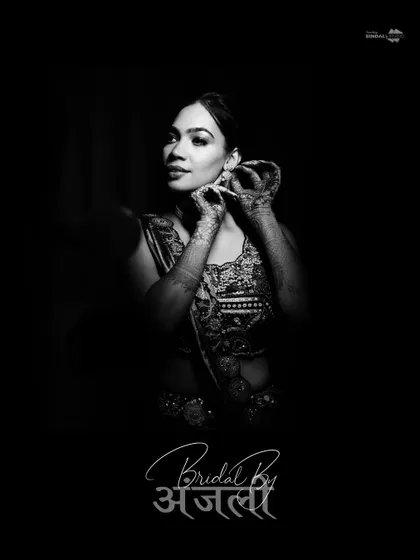 A classic black and white portrait with a beautiful calligraphy overlay. The bride is captured in a moment of quiet preparation, adjusting her earring.