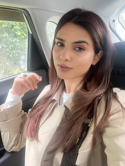 A car selfie showing off my fresh blowout and classic trench coat.