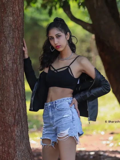 This outdoor portrait captures a confident pose against a tree, showcasing a relaxed yet stylish vibe perfect for a lifestyle shoot.