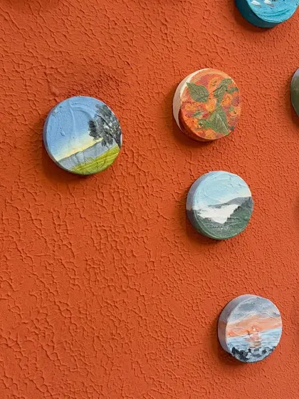 An angled view showing the three-dimensional quality of the miniature art pieces as they sit on the main board.