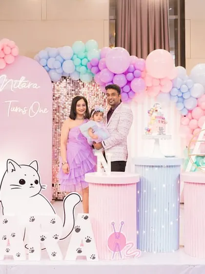 The family poses for a photo at their daughter's adorable cat-themed first birthday party.