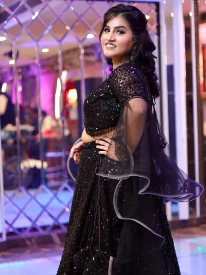 A side view of her party look, showing the half-up hairstyle with soft curls that adds a touch of elegance.