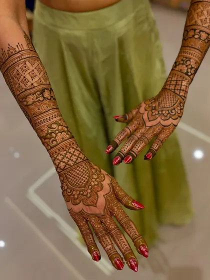 A full view of the wedding mehendi, showing the design extending up both arms.