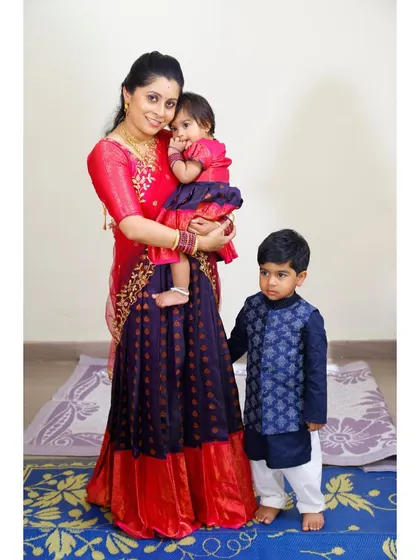 I love creating outfits for the entire family. Here, I designed a matching concept for a mother, daughter, and son using a beautiful red and royal blue silk fabric. The mother's half-saree, daughter's pattu pavadai, and son's kurta create a perfectly coordinated look for family portraits and events.